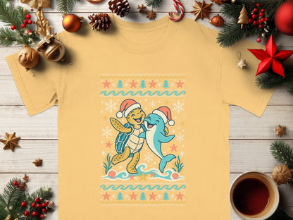 Yellow t-shirt with a cartoon turtle and dolphin wearing Santa hats and a beach-themed ugly Christmas sweater pattern.