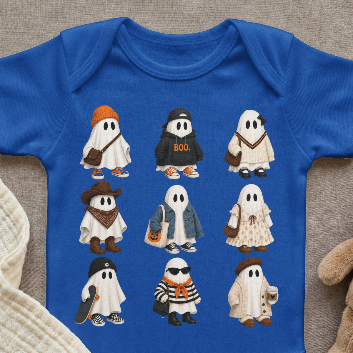 Nine illustrated ghosts in various Halloween-themed outfits and accessories on a blue onesie.