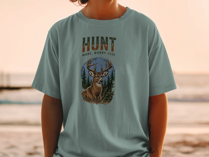T-shirt graphic with deer, trees, and text "HUNT MORE, WORRY LESS".