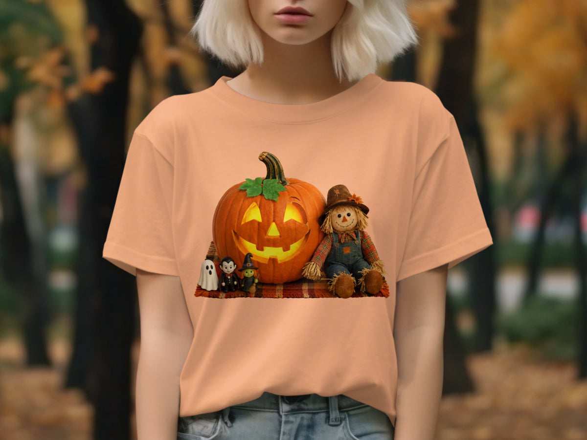 Peach t-shirt with Halloween graphic of pumpkin, scarecrow, witch, vampire, and ghost.
