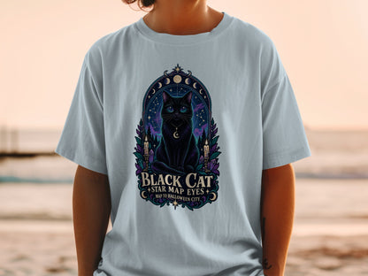 Black cat with star map eyes on a t-shirt with text "Black Cat Star Map Eyes Map to Halloween City".