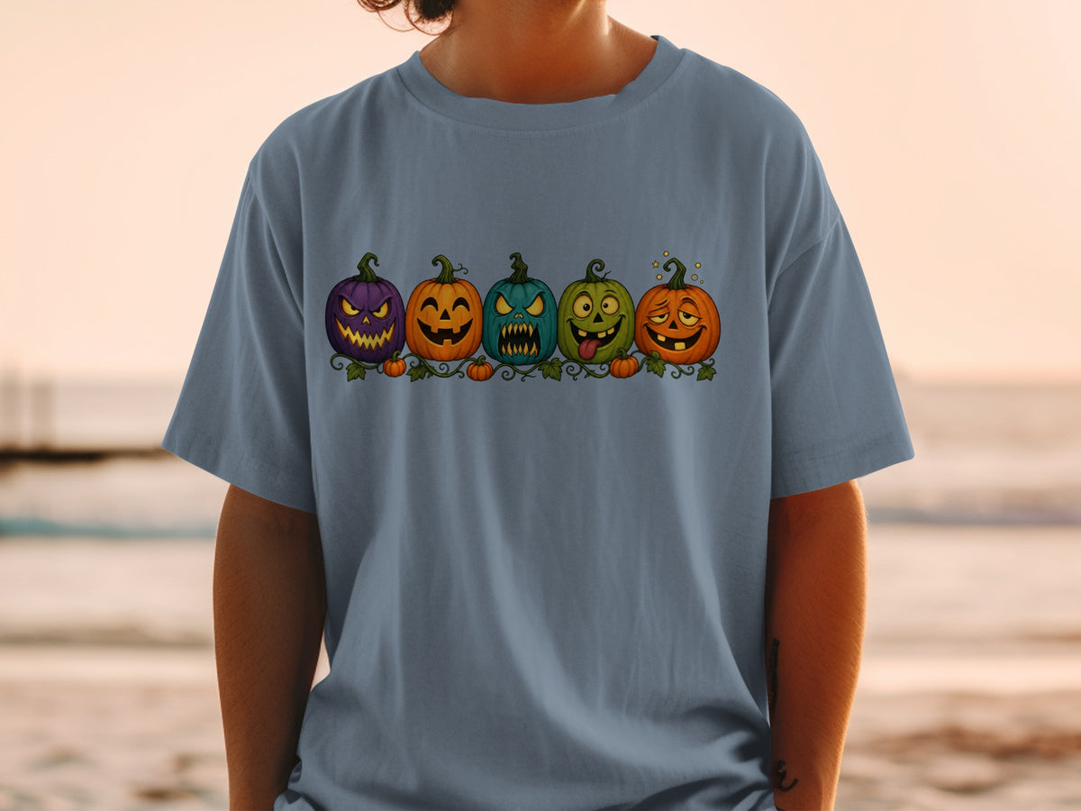 Five cartoon jack-o'-lanterns with various expressions across a t-shirt.