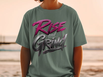 T-shirt with pink and silver "Rise and Grind" graphic on a green shirt.