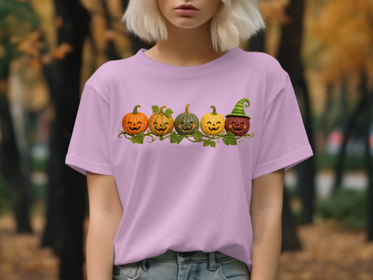 Five carved pumpkins with smiling faces and vines on a purple t-shirt.