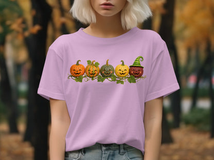 Five carved pumpkins with smiling faces and vines on a purple t-shirt.