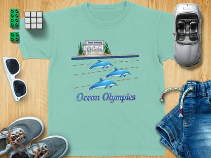 Teal t-shirt with cartoon dolphins racing and text "Ocean Olympics".