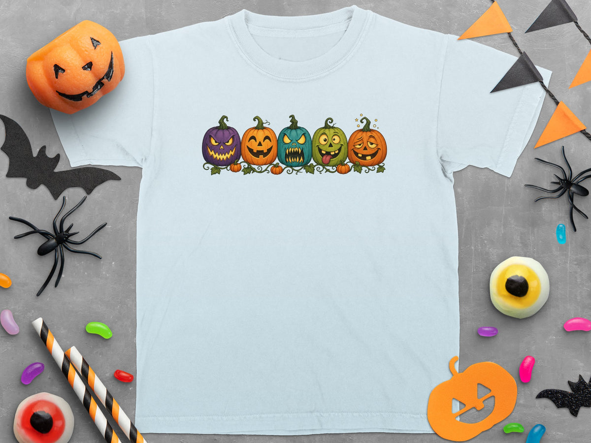 Light blue t-shirt with five cartoon pumpkins of various colors and expressions.
