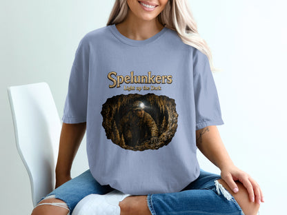 Spelunkers light up the dark graphic on a light blue t-shirt.