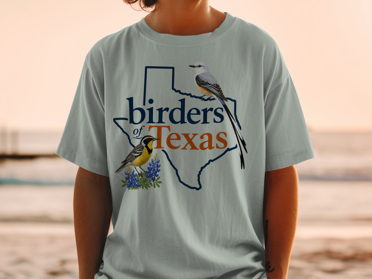 Light blue t-shirt with "birders of Texas" text and two illustrated birds on Texas outline.
