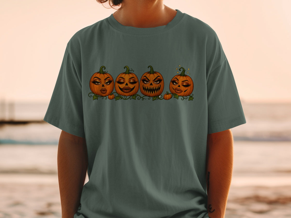 Four cartoon pumpkins with glamorous makeup in a row on a green t-shirt.