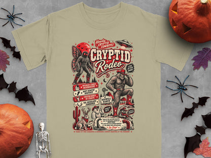 Cryptid Rodeo graphic on a beige t-shirt with Mothman, Bigfoot, Jackalope, Chupacabra, and UFO.