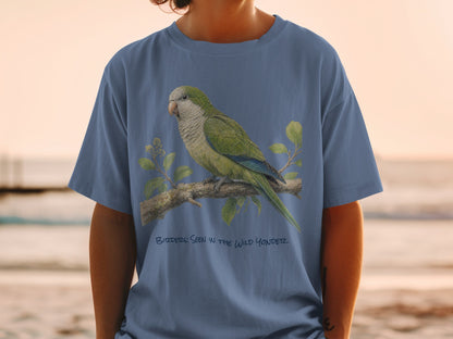 Blue t-shirt with illustration of a green parrot on a branch and text "Birders: Seen in the Wild Yonder".
