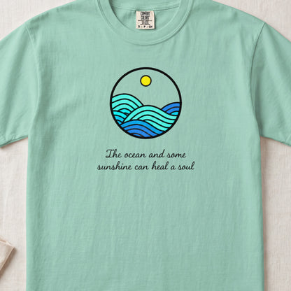 Mint green t-shirt featuring a circular ocean graphic and the text The ocean and some sunshine can heal a soul.