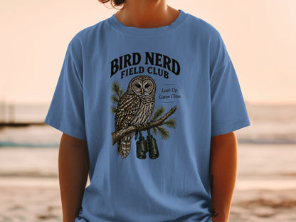 Blue t-shirt with bird art featuring an owl, binoculars, and text "Bird Nerd Field Club."