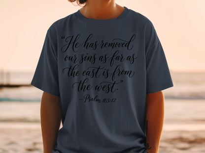 Dark blue t-shirt with script text: "He has removed our sins as far as the east is from the west." - Psalm 103:12.
