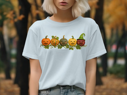 Five carved pumpkins with smiling faces adorn a vine on a light blue t-shirt.