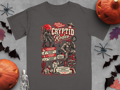 T-shirt graphic with "Cryptid Rodeo" featuring Bigfoot, Mothman, and other mythical creatures.