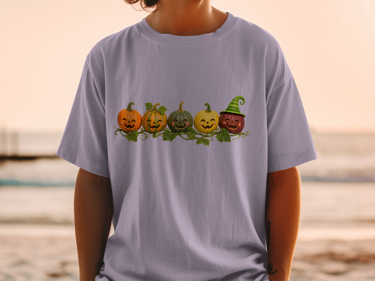 T-shirt with row of smiling cartoon pumpkins and a witch hat.