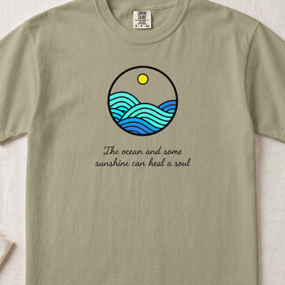 Sage green t-shirt with a round ocean graphic and the text The ocean and some sunshine can heal a soul.