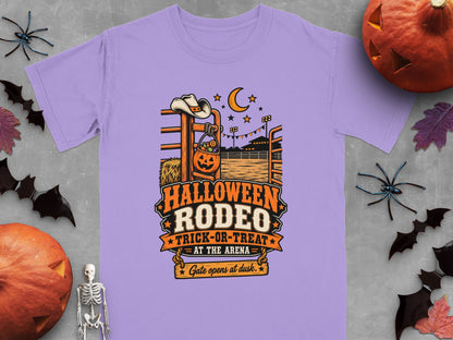 Purple t-shirt with Halloween Rodeo trick-or-treat design and autumn decorations.