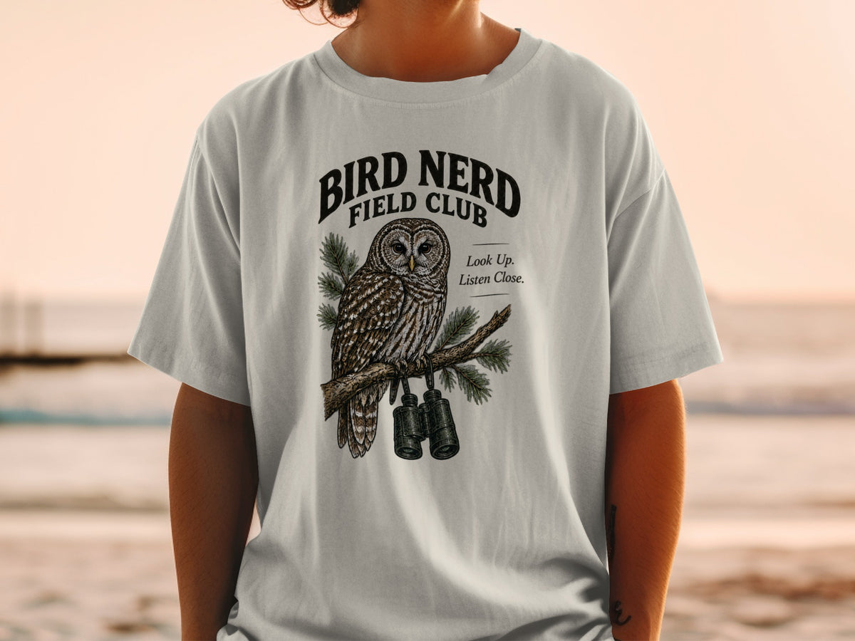 Light gray t-shirt with a detailed owl graphic and text "Bird Nerd Field Club".
