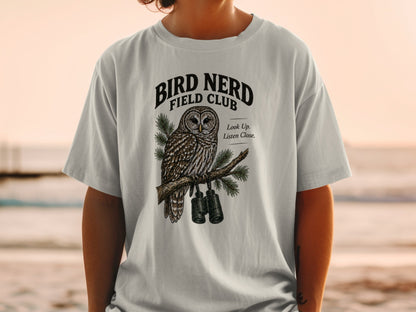 Light gray t-shirt with a detailed owl graphic and text "Bird Nerd Field Club".