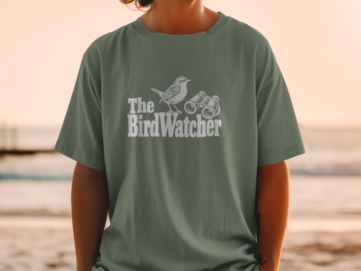 The BirdWatcher text with a bird and binoculars graphic on a green t-shirt.