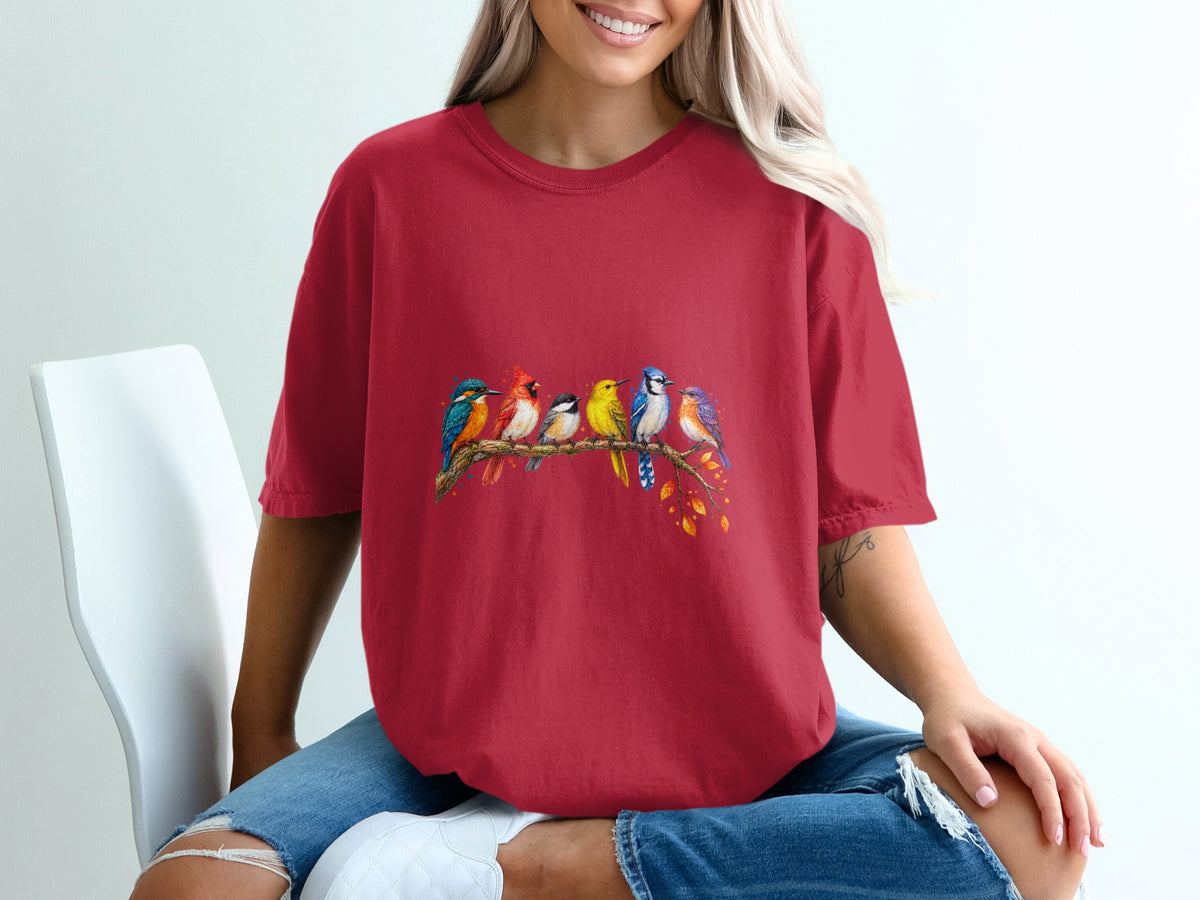 Red t-shirt with a watercolor design of six colorful birds perched on a branch.