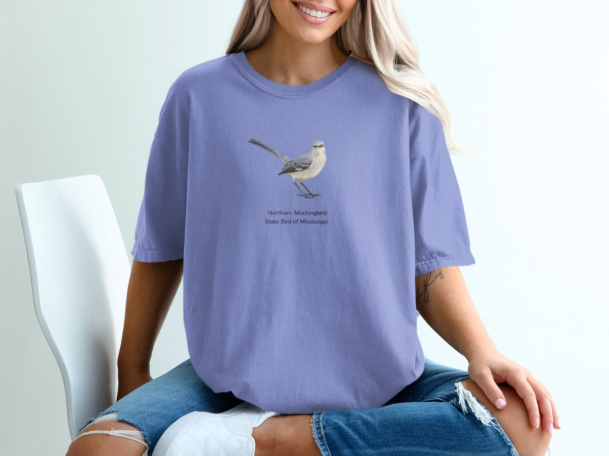 Northern Mockingbird illustration with text "State Bird of Mississippi" on purple t-shirt.