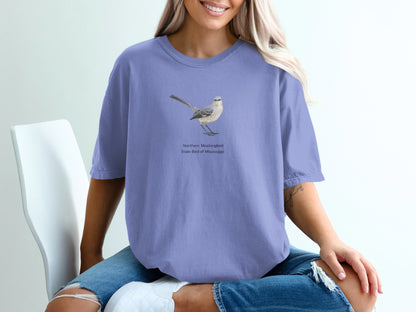 Northern Mockingbird illustration with text "State Bird of Mississippi" on purple t-shirt.