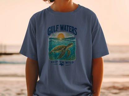 T-shirt graphic of a sea turtle swimming with "GULF WATERS" and "KEEP 'EM WILD" text.