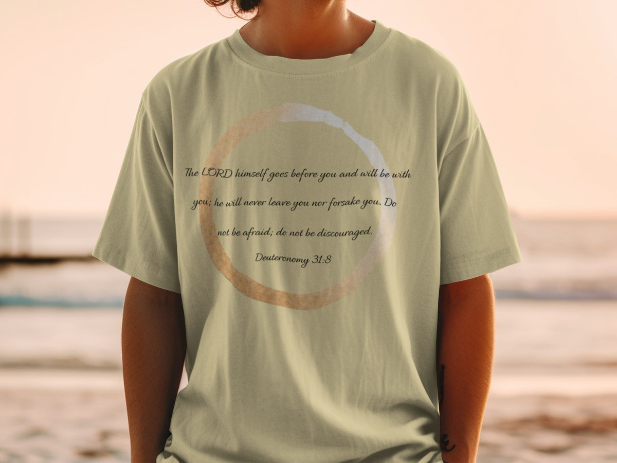 Light tan t-shirt with text "The LORD himself goes before you and will be with you; he will never leave you nor forsake you. Do not be afraid; do not be discouraged. Deuteronomy 31:8".