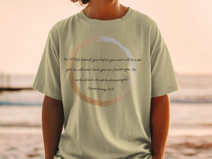 Light tan t-shirt with text "The LORD himself goes before you and will be with you; he will never leave you nor forsake you. Do not be afraid; do not be discouraged. Deuteronomy 31:8".
