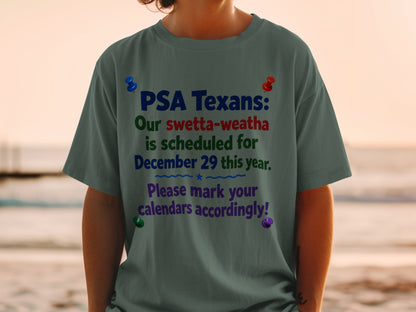 Dark grey t-shirt with text "PSA Texans: Our swetta-weatha is scheduled for December 29 this year. Please mark your calendars accordingly!"