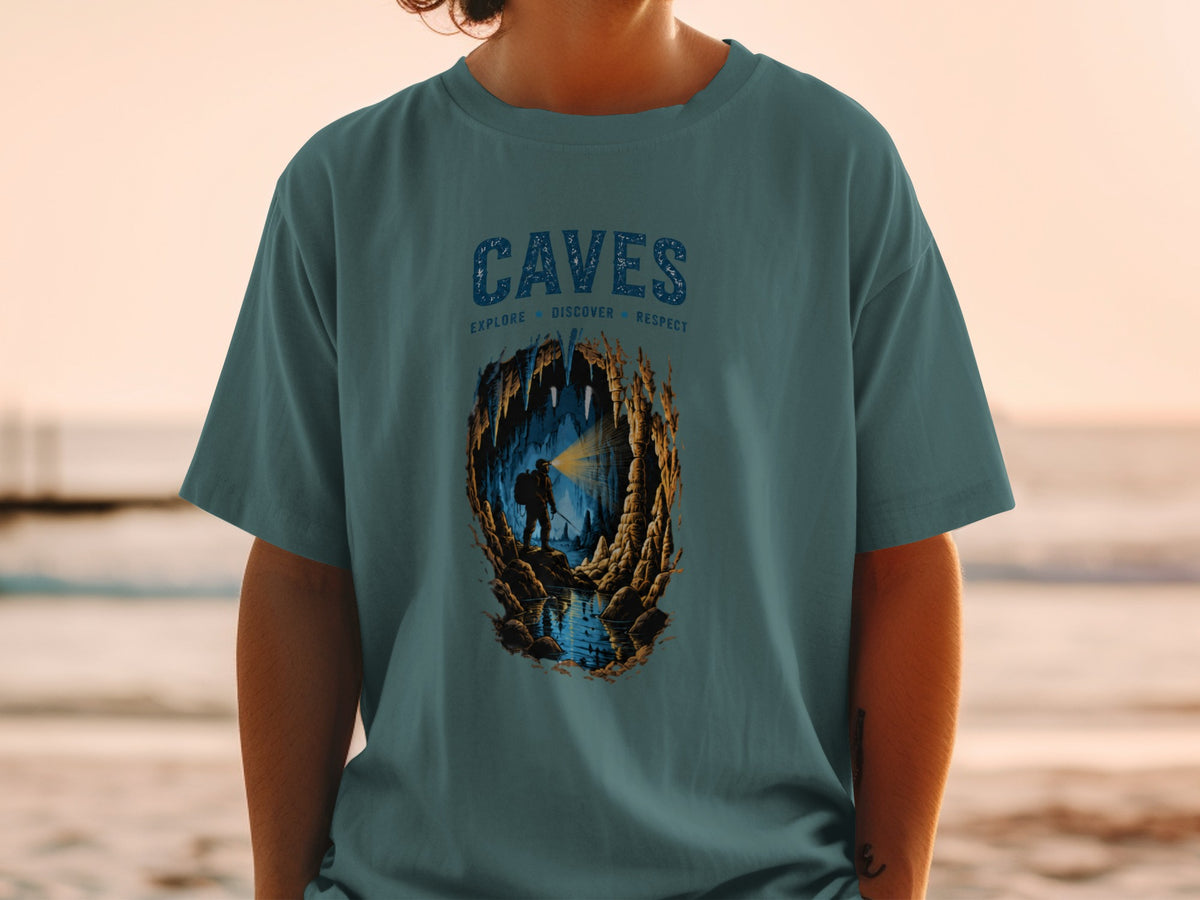 T-shirt graphic with "CAVES" text and illustration of caver exploring an underground cave.