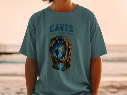 T-shirt graphic with "CAVES" text and illustration of caver exploring an underground cave.
