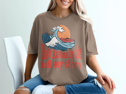 Brown t-shirt with wave graphic and text "The Ocean and my tats tell my story".