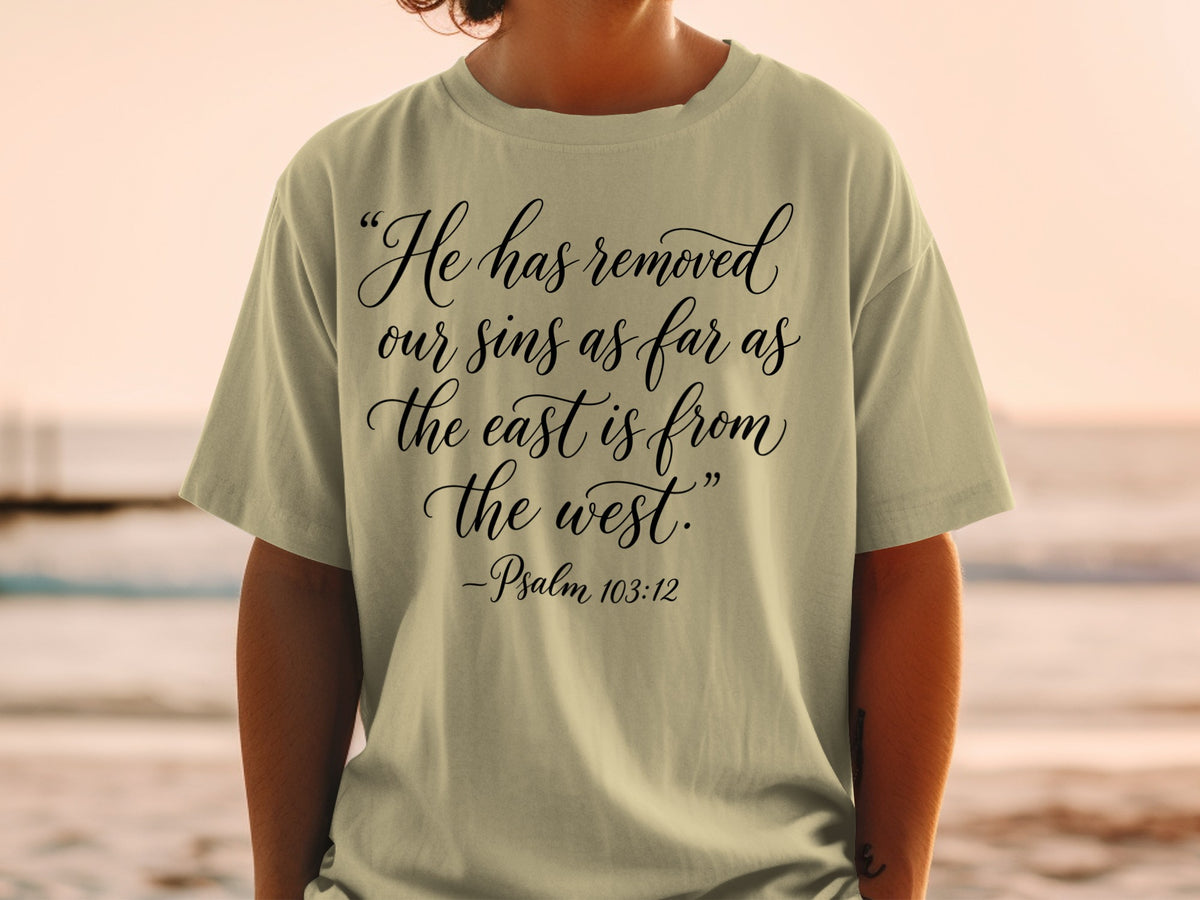 Light tan t-shirt with "He has removed our sins as far as the east is from the west." -Psalm 103:12