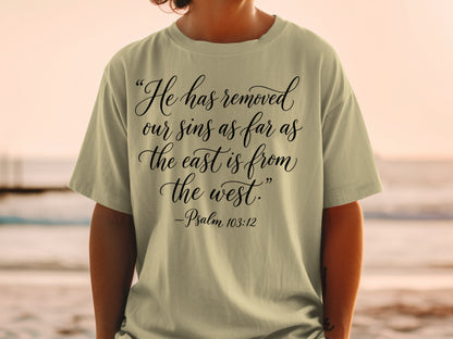 Light tan t-shirt with "He has removed our sins as far as the east is from the west." -Psalm 103:12