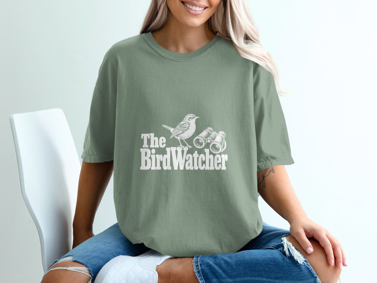 Green t-shirt with white text and graphic of a bird and binoculars.
