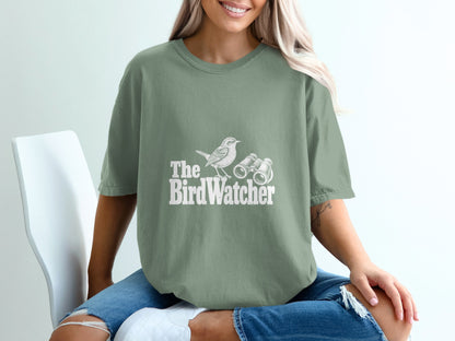 Green t-shirt with white text and graphic of a bird and binoculars.