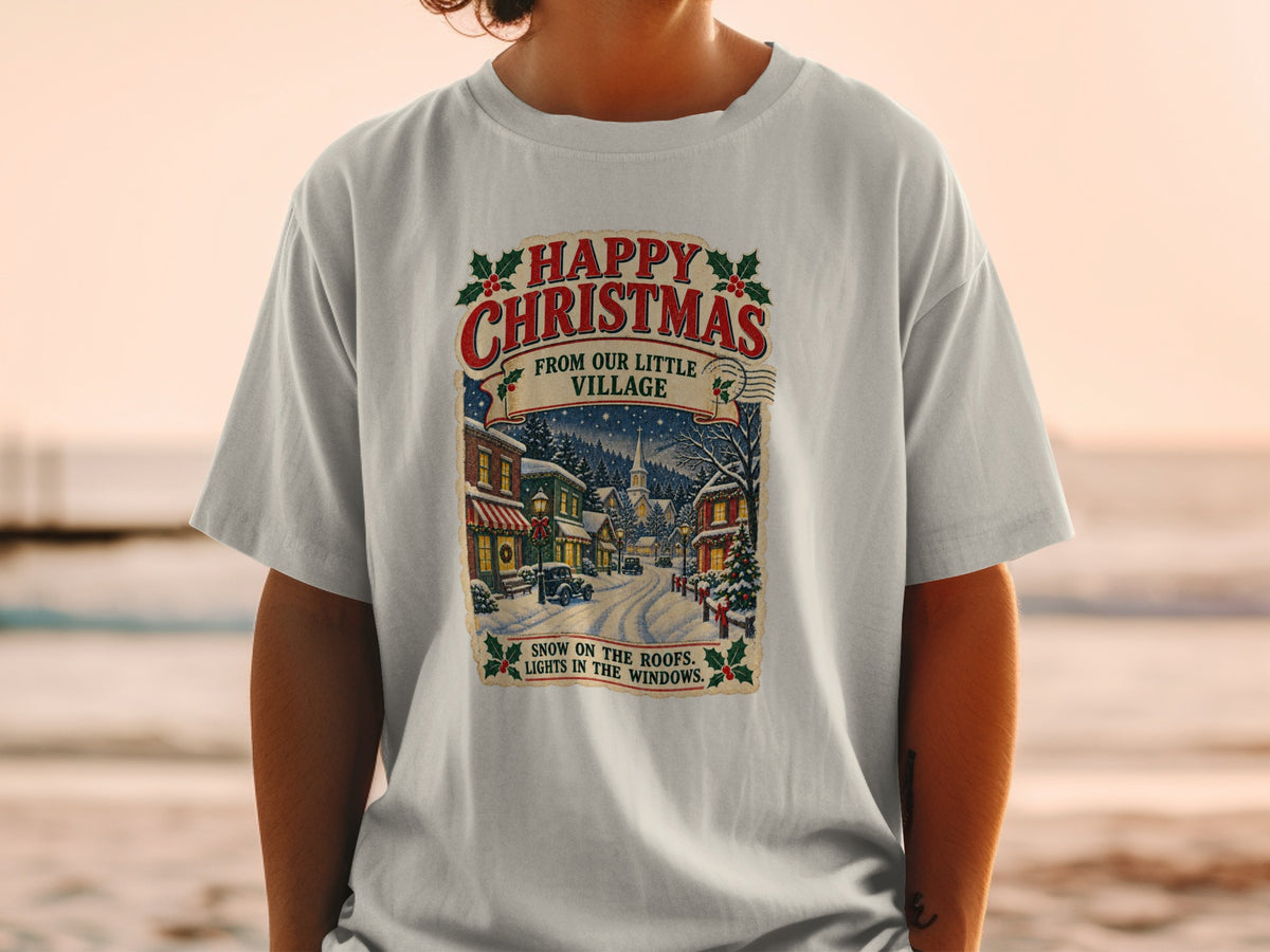 T-shirt with vintage Christmas village scene and text "Happy Christmas From Our Little Village".