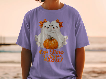 Two cute ghosts hug a pumpkin with the text "Our Time of the Year, at Last!"