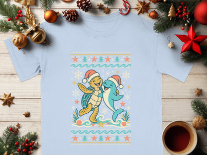 Light blue t-shirt with cartoon turtle and dolphin wearing Santa hats.