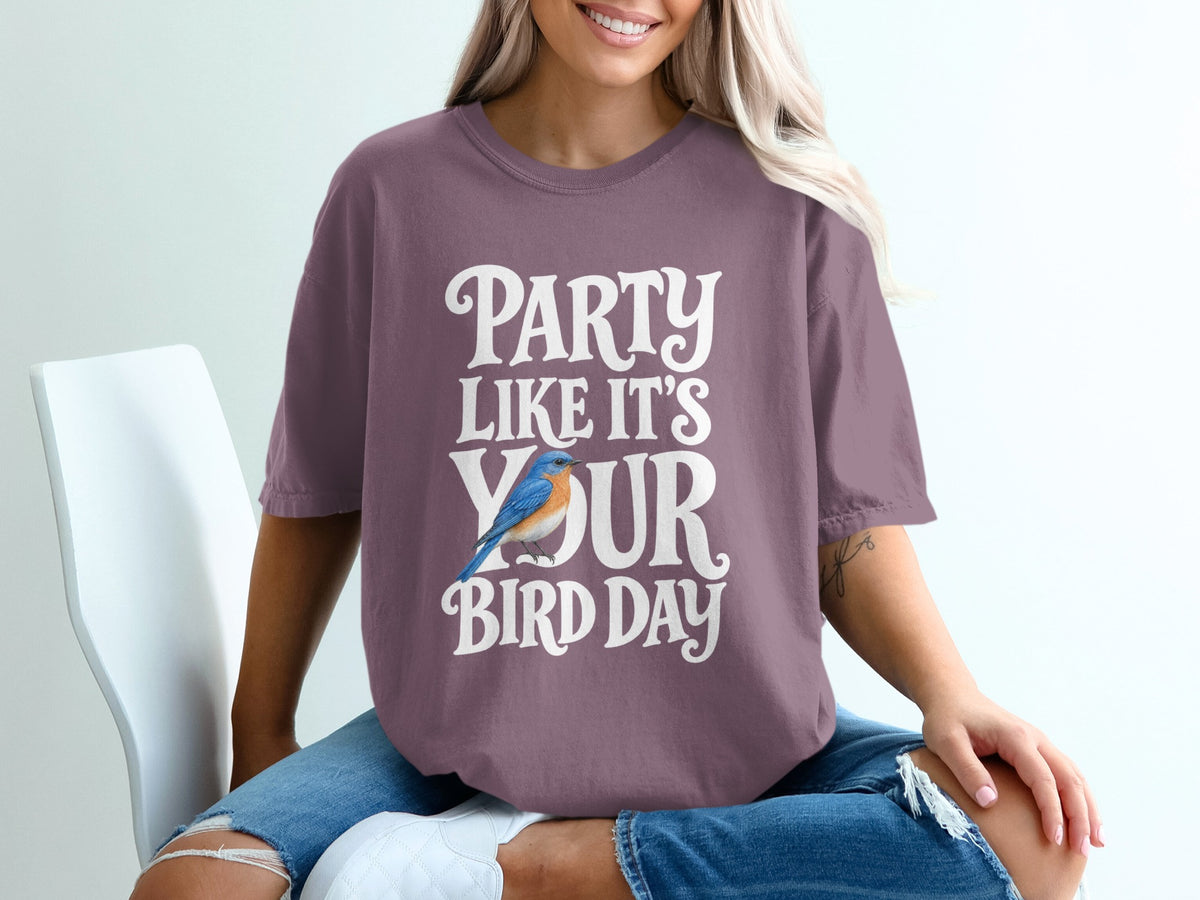 Purple t-shirt with white text reading "PARTY LIKE IT'S YOUR BIRD DAY" and a blue bird graphic.
