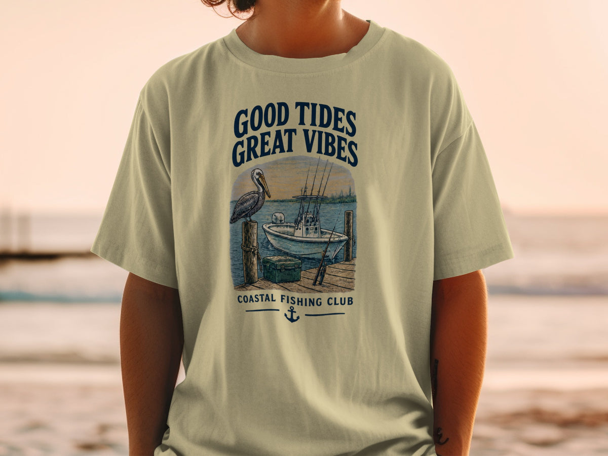 T-shirt graphic with text: Good Tides Great Vibes, pelican, boat, dock, and Coastal Fishing Club.