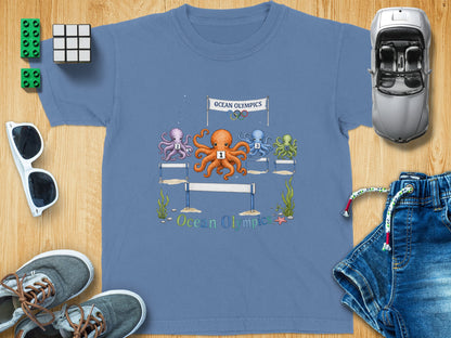 Octopuses race hurdles under an "Ocean Olympics" banner with Olympic rings.