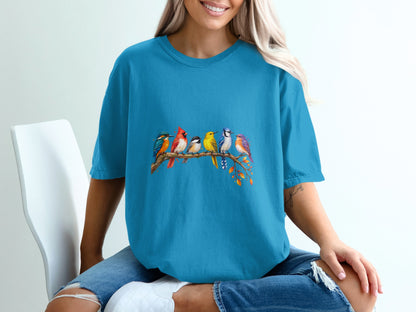 Blue t-shirt with colorful birds perched on a tree branch graphic.