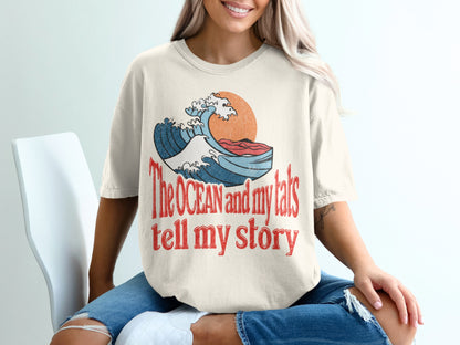 Cream t-shirt with "The OCEAN and my tats tell my story" text and wave graphic.