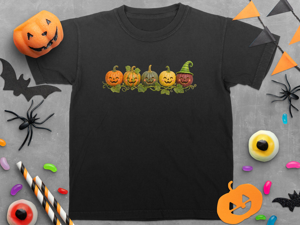 Black t-shirt with a row of five grinning pumpkins and Halloween decorations.